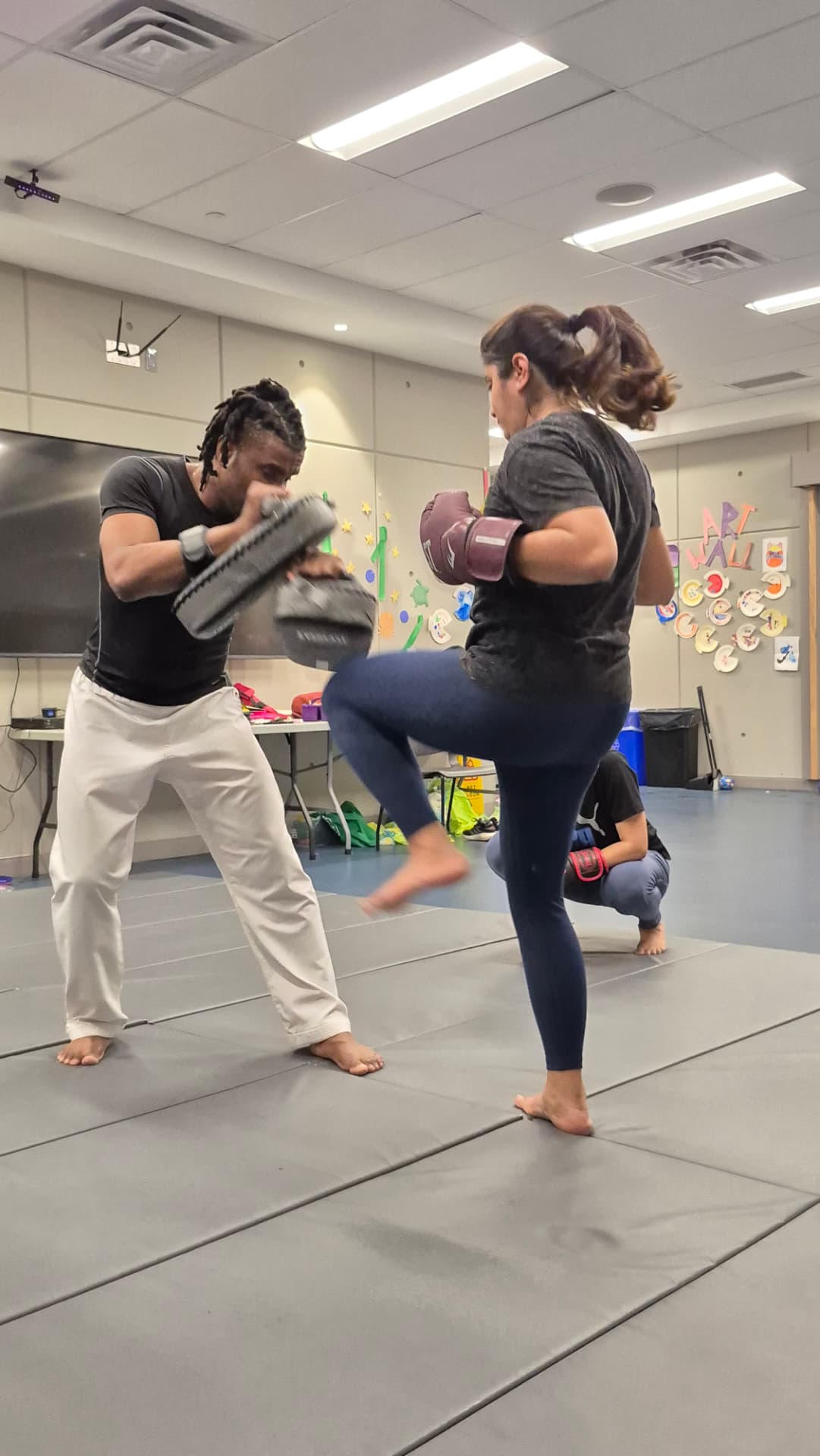 Adults train kickboxing footwork and guard positions in the gym